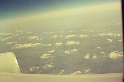 Scattered clouds over farmland seen from the plane — In transit, in transit (20-25 May 2000)