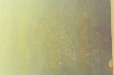 A faint town and fields glimpsed through the haze — In transit, in transit (20-25 May 2000)