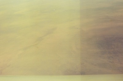 Hazy arid land seen through a scratched window — In transit, in transit (20-25 May 2000)