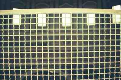 Sunlit windows behind a wire grille in St Peter's — St Peter's Basilica, Vatican City (21-27 May 2000)