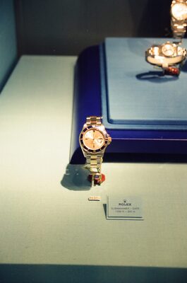 A gold Rolex watch on display behind a label — Geneva, Switzerland (1 July 2000)