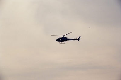 A helicopter flying against a pale sky — Geneva, Switzerland (1 July 2000)