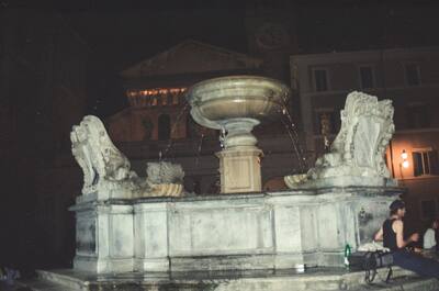 A floodlit lion fountain in a night piazza — Rome, Italy (21-27 May 2000)