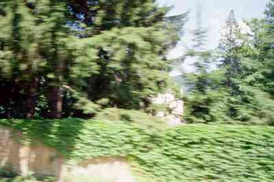 A castle glimpsed through trees from the moving bus — Salzkammergut region, Austria (16-18 June 2000)