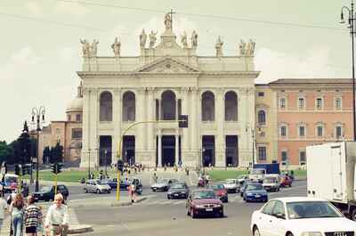The basilica facade with statues seen across the traffic — Rome, Italy (late May 2000)