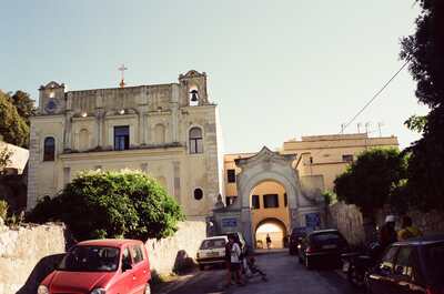 An old town church and arched gate with parked cars — Gaeta & the coast, Italy (28 May - 3 June 2000)