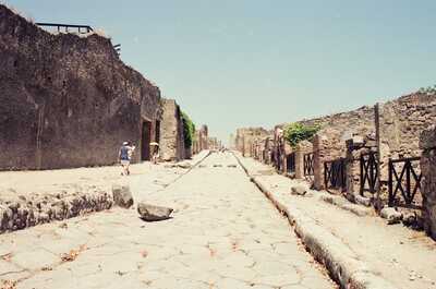 A paved ancient street between ruined buildings — Pompeii, Italy (28 May - 3 June 2000)