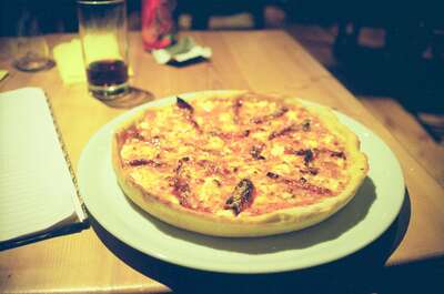 A cheese pizza on a white plate beside a notebook — Ireland, Ireland (4-9 July 2000)