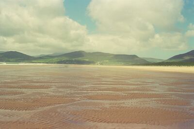 Rippled wet sand of a vast tidal strand below green hills — Dingle Peninsula, Ireland (4-9 July 2000)