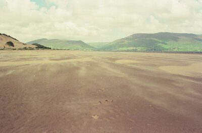 Wind-swept dunes and beach beneath rolling green mountains — Dingle Peninsula, Ireland (4-9 July 2000)