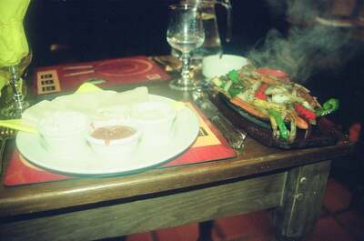 A sizzling fajita platter and tortillas on a restaurant table — Ireland, Ireland (4-9 July 2000)