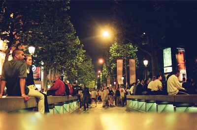 A couple resting on a planter on the Champs-Elysees at night — Paris, France (2-8 July 2000)