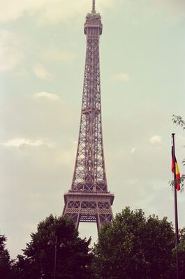 The full Eiffel Tower rising past a tricolour flag — Paris, France (2-8 July 2000)