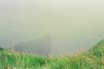 A misty drop to the sea from a grassy clifftop — County Clare, Ireland (29 June - 6 July 2000)