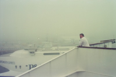 A man at the rail of a ferry in heavy fog at the port — Portsmouth, England (29 June - 6 July 2000)