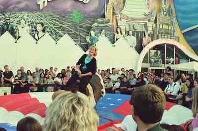 A woman riding a mechanical bull before a crowd in Disney Village — Disneyland Paris, France (29 June - 6 July 2000)