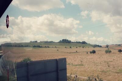 A grassy downland hill fort seen from the bus window — Wiltshire, England (mid-August 2000)