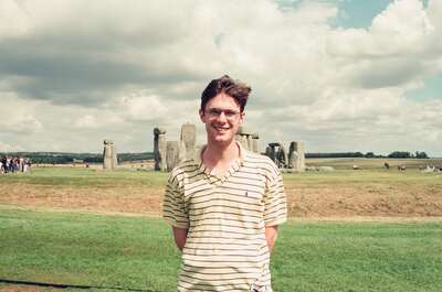 Richard smiling in front of the Stonehenge circle — Stonehenge, England (mid-August 2000)