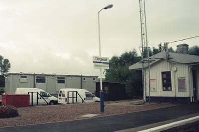 Dingwall railway station with parked vans and a tall mast — Dingwall, Scotland (late July 2000)