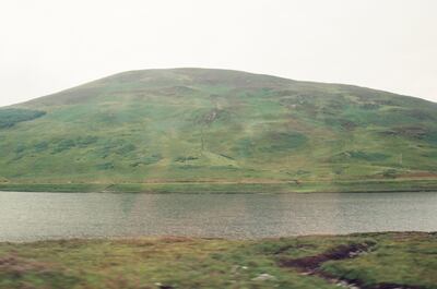 A bare green hill rising above a Highland loch — Scottish Highlands, Scotland (late July 2000)