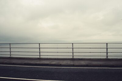 The causeway railing and grey sea on the Skye Bridge approach — Isle of Skye, Scotland (late July 2000)