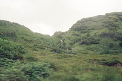 A lush green glen folded between steep hillsides — Scottish Highlands, Scotland (late July 2000)