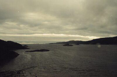 Skerries scattered across a dark sea loch at low tide — Scottish Highlands, Scotland (late July 2000)