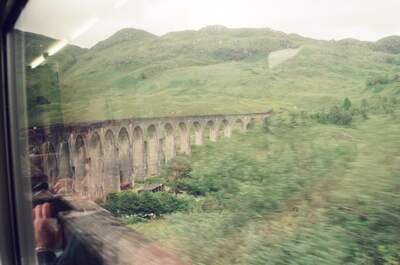 The Glenfinnan Viaduct curving across a green hillside — Glenfinnan, Scotland (late July 2000)