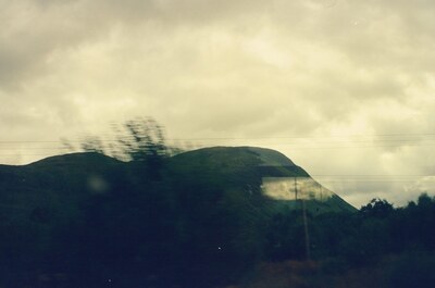A brooding hill with reflections on the train glass — Fort William, Scotland (August 2000)