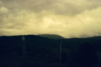 Power lines crossing a cloud-darkened Highland hillside — Scottish Highlands, Scotland (August 2000)
