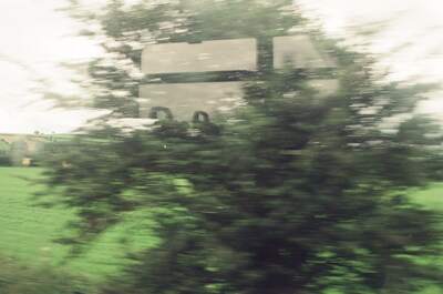 Blurred countryside and a road sign from a train — rural England/Wales, England (August 2000)
