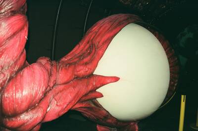 A clawed monster gripping a glowing egg in the Body Zone — London, England (August 2000)