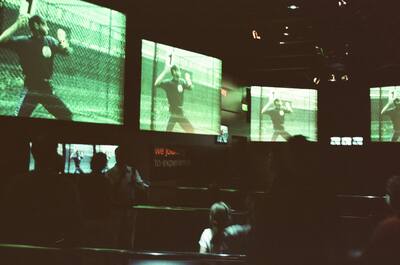 Projection screens of athletes in the dark Mind Zone — London, England (August 2000)