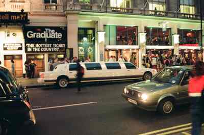 A white stretch limousine outside the Gielgud Theatre at night — London, England (August 2000)