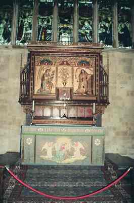 A carved canopied tomb against stained-glass windows — Winchester, England (August 2000)