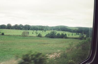 Green pasture and woods from a train window — Aberdeen, Scotland (late July - early August 2000)