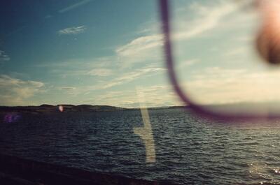 Sea and low hills seen through a train window — Aberdeen, Scotland (late July - early August 2000)