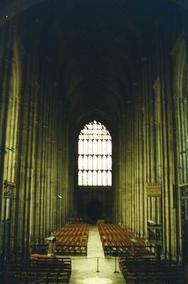 A great west window glowing at the end of the dim nave — Canterbury, England (mid-August 2000)