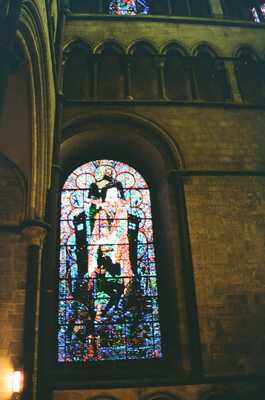 A vivid figural stained glass window set in the stone wall — Canterbury, England (mid-August 2000)