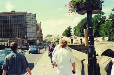 People crossing Lendal Bridge past a flowering lamp post — York, England (mid-August 2000)
