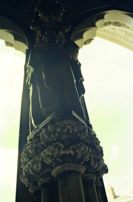 A dark draped statue against a bright Minster window — York, England (mid-August 2000)