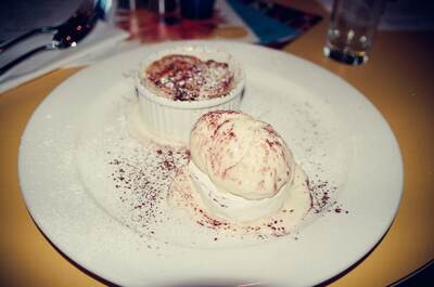 A dusted dessert and quenelle of cream on a white plate — Edinburgh, Scotland (August 2000)