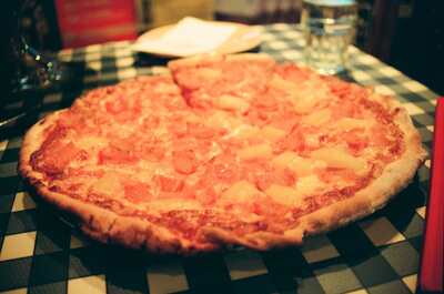 A pineapple pizza on a checked tablecloth — Edinburgh, Scotland (August 2000)