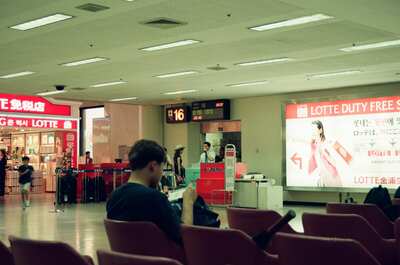 Travellers waiting near the Lotte Duty Free shop — Seoul, in transit (August 2000)