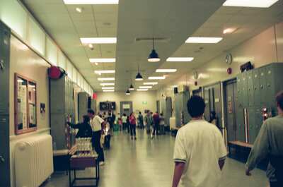 Visitors walking a corridor lined with lockers — London, England (August 2000)