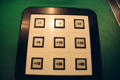 A grid of numbered scoring panels on green felt — London, England (August 2000)
