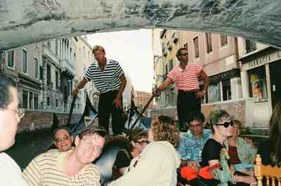 Two gondoliers steering passengers beneath a low bridge — Venice, Italy (7-10 June 2000)