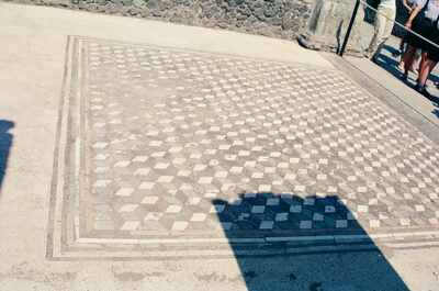 Tourists viewing a geometric floor mosaic at Herculaneum — Herculaneum, Italy (4-6 June 2000)