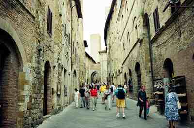 A medieval stone street leading to a tower — San Gimignano, Italy (6-10 June 2000)