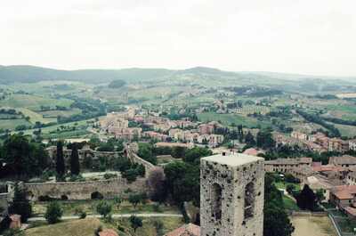 A stone tower above San Gimignano with hills beyond — San Gimignano, Italy (6-10 June 2000)